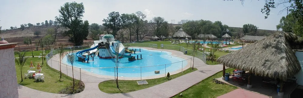 Panorámica del balneario Aqualandia con alberca recreativa, toboganes y palapas